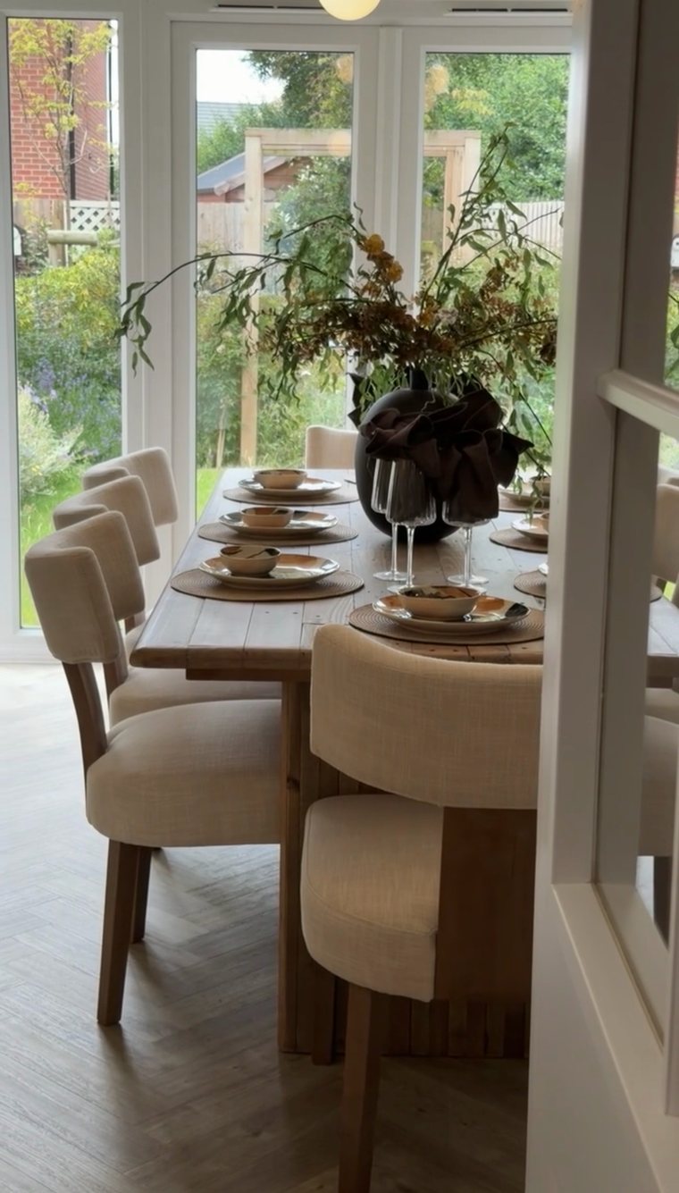 Dining table set for eight in front of garden doors