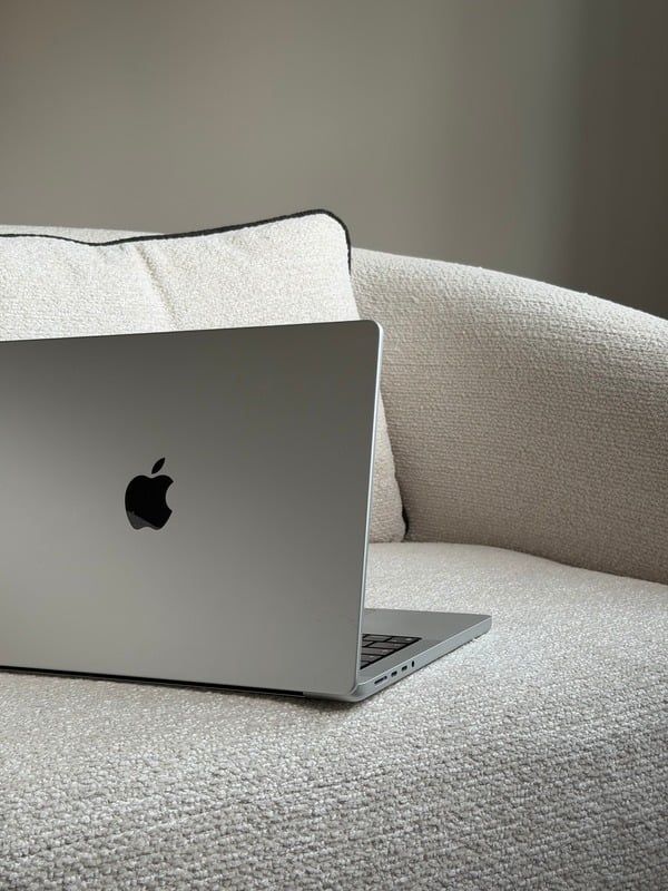 Laptop resting on a cream sofa