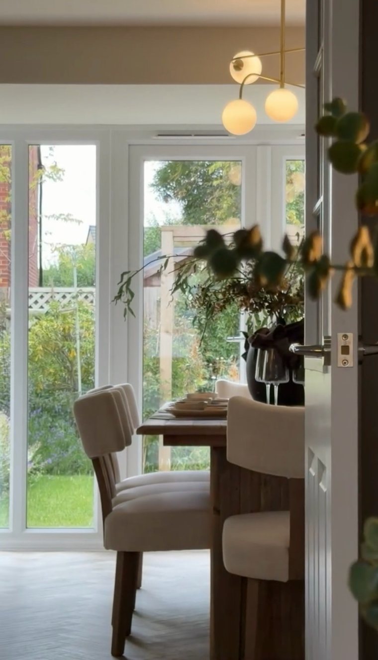 Dining room glimpsed through an open door under a globe pendant