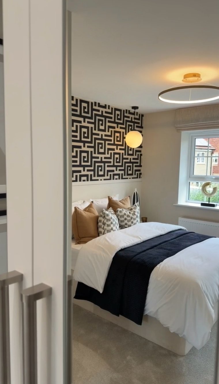 Bedroom with a monochrome geometric feature wall, seen through a doorway